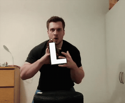 Man In Black Shirt Holding Large L GIF