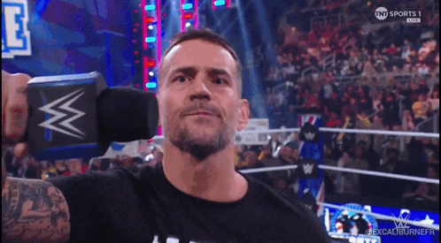 Man In Black Shirt Holding Microphone With W GIF