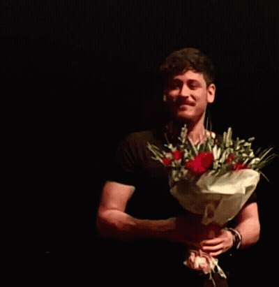 Man in Black Shirt Holding Red Roses