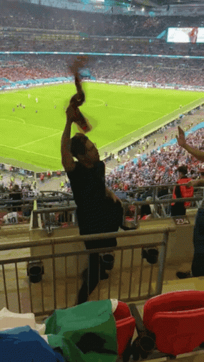 Man In Black Shirt Holding Scarf Soccer Field GIF