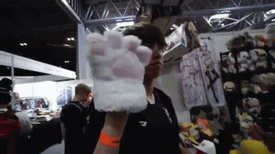 Man In Black Shirt Holding White Paw Glove GIF