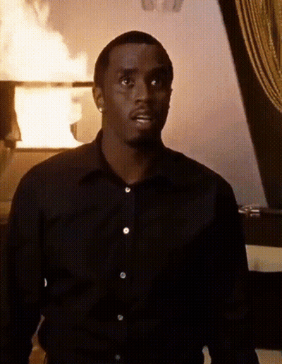 Man In Black Shirt In Front Of Burning Building GIF