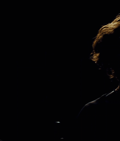 Man In Black Shirt In Front Of Circle In Dark GIF