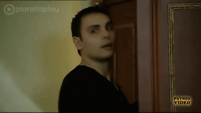Man In Black Shirt In Front Of Payne Video Door GIF
