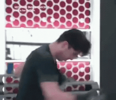 Man In Black Shirt In Front Of Red Circle Wall GIF
