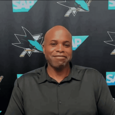 Man In Black Shirt In Front Of SAP Sharks Logos GIF