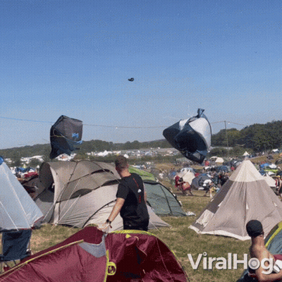 Man In Black Shirt In Front Of Tents GIF