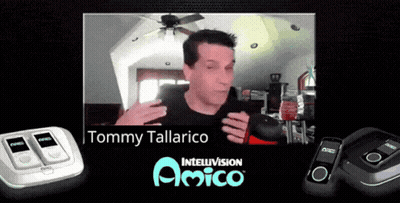 Man In Black Shirt In Front Of Tommy Tallarico Sign GIF