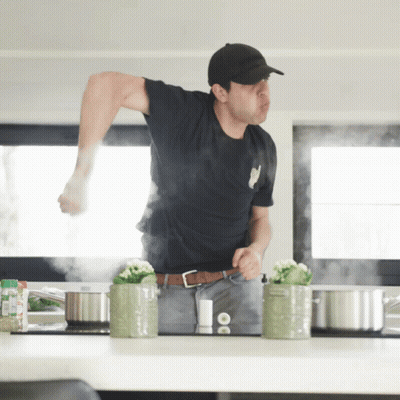 Man In Black Shirt In Kitchen With Pots GIF