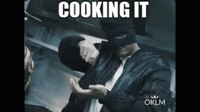 Man In Black Shirt In Kitchen With Pots GIF
