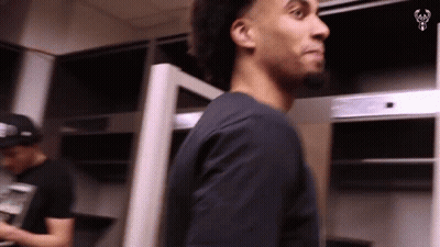 Man In Black Shirt In Locker Room Looking At Something GIF