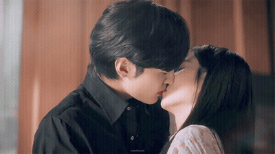 Man In Black Shirt Kissing Woman In White Dress GIF