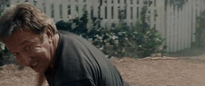 Man In Black Shirt Laying On Ground With White Picket Fence GIF