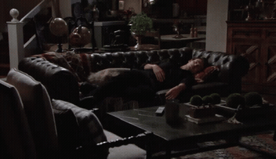 Man In Black Shirt Laying On Leather Couch GIF