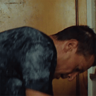 Man In Black Shirt Leaning Against Wall GIF