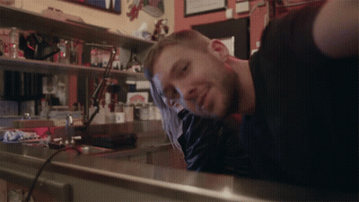 Man In Black Shirt Leaning On Counter GIF