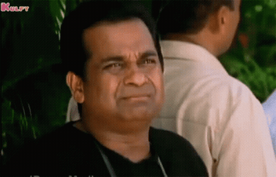 Man In Black Shirt Making Funny Face In Front Of Group GIF