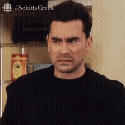 Man In Black Shirt Making Funny Face Looking At Camera GIF