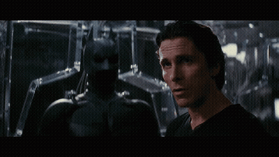 Man In Black Shirt Next To Batman Statue GIF