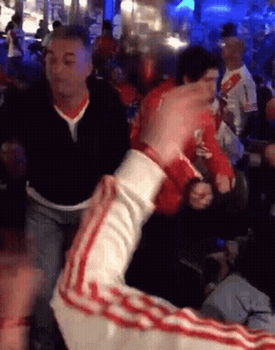 Man In Black Shirt Number 1 Holding Another Man's Arm In Crowd GIF