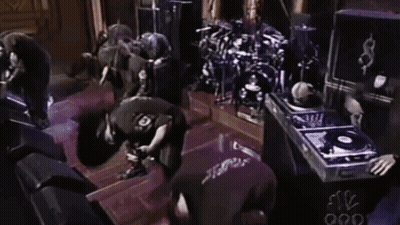 Man In Black Shirt Number 10 Kneeling At Drum Set GIF
