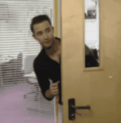 Man In Black Shirt Peeking Out Of Door GIF