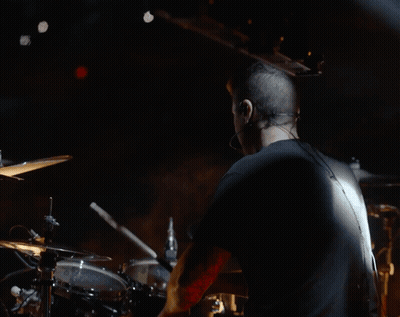 Man In Black Shirt Playing Drums In Dark Room GIF