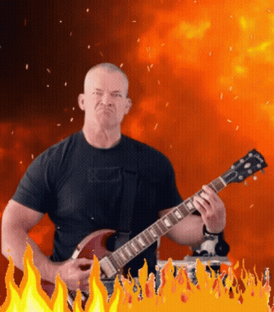 Man In Black Shirt Playing Gibson Guitar In Front Of Flames GIF