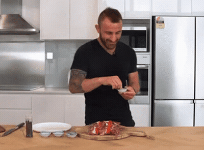 Man In Black Shirt Preparing Food In Kitchen With Miele Refrigerator GIF
