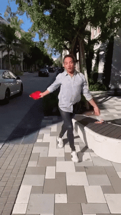 Man In Black Shirt Reaching Toward Lamp With Clueless GIF