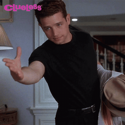 Man In Black Shirt Reaching Toward Lamp With Clueless GIF