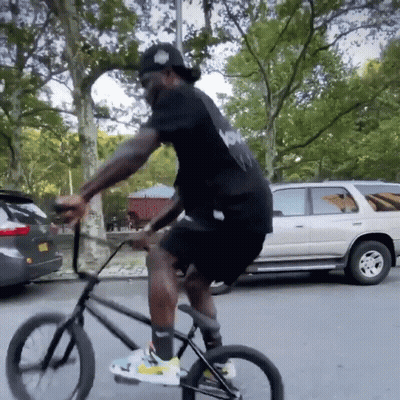 Man In Black Shirt Riding Bike GIF