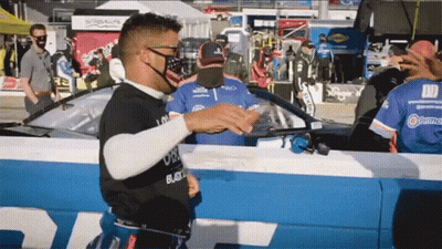 Man In Black Shirt Saying Black In Front Of Race Car GIF