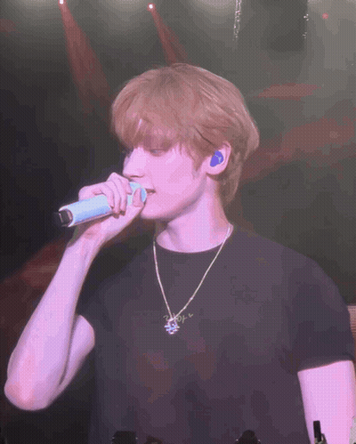 Man In Black Shirt Singing Into Microphone On Stage GIF