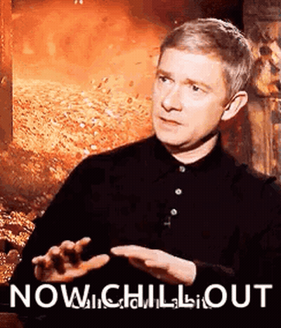 Man In Black Shirt Sitting By Fire Saying Now Chill Out GIF