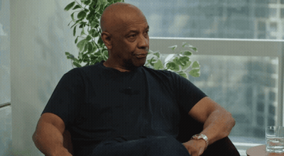 Man In Black Shirt Sitting By Window With Plant GIF