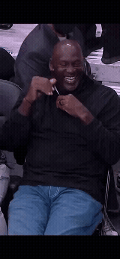 Man In Black Shirt Sitting In Chair Smiling GIF