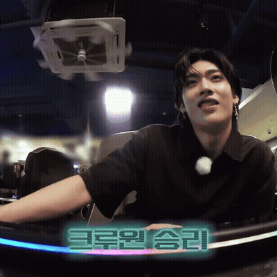 Man In Black Shirt Sitting In Front Of Korean Sign GIF