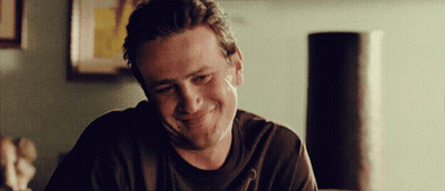 Man In Black Shirt Smiling In Front Of Lamp GIF