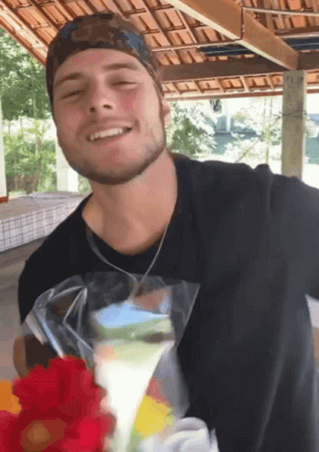 Man In Black Shirt Smiling While Holding Bag Of Food GIF