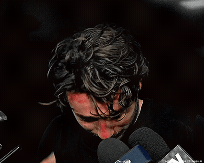 Man In Black Shirt Speaking Into Microphone GIF