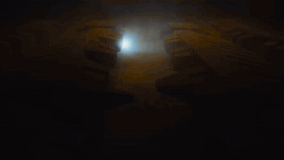 Man In Black Shirt Standing In Front Of Circle In Dark GIF