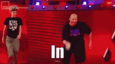 Man In Black Shirt Standing In Front Of Crowd Saying In GIF