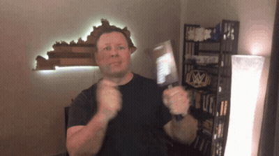 Man In Black Shirt Standing In Front Of Shelf Saying I Love You GIF