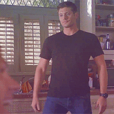 Man In Black Shirt Standing In Front Of Window GIF