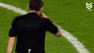 Man In Black Shirt Standing On Soccer Field Hands On Hips GIF