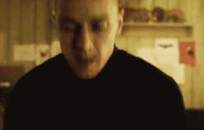 Man In Black Shirt Standing With Eyes Closed In Dark Room GIF