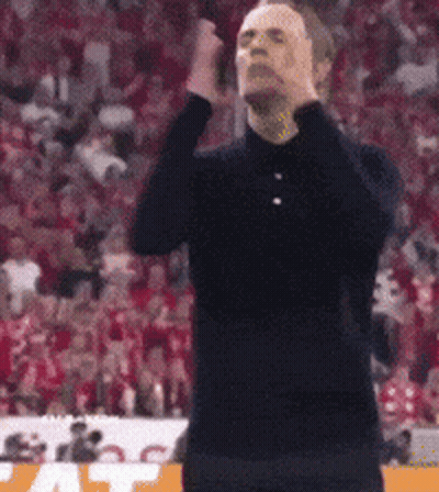 Man In Black Shirt Standing With Hands On Head GIF