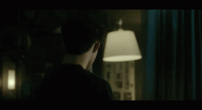 Man in Black Shirt Standing With Lamp in Dark Room