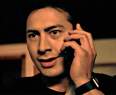 Man In Black Shirt Talking On Cellphone GIF